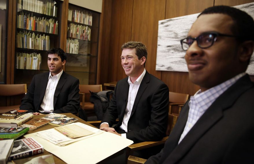 Emory University students, from left, Brett Lake, Warren Kember and Kyle Arbuckle sit around the school's collection of Hank Aaron materials, Monday, April 7, 2014, in Atlanta. The three university baseball players teamed up last year to dig through the collection, donated in 2013 by a former scout for the Atlanta Braves. (AP Photo/David Goldman)