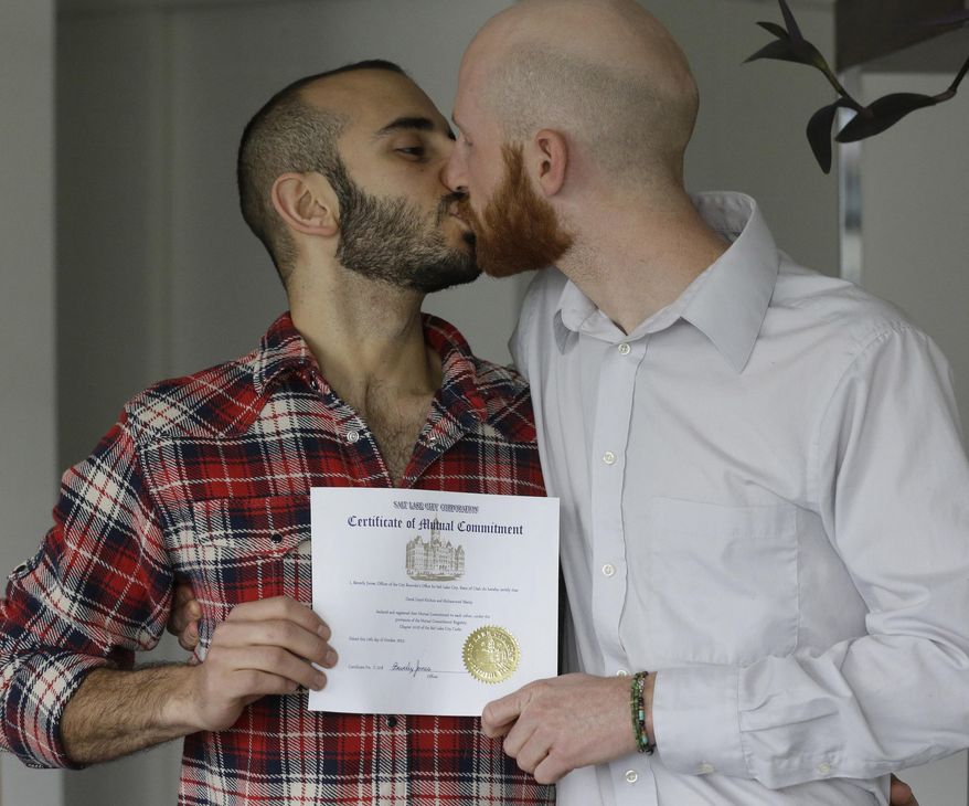 In this April 3, 2014, photo, Derek Kitchen, right, and Moudi Sbeity kiss as they hold their certificate of mutual commitment at their home, in Salt Lake City. The young couple that has become the face of gay marriage in Utah is an unlikely pair for the role. Kitchen and Sbeity were both raised in conservative religious families that shun gays, Kitchen in a Mormon home in Utah and Sbeity in a Muslim family in Lebanon. They each came out when they were 16 years old, worlds apart, and met six years later in college in Utah. They chose to become one of three couples as plaintiffs in the lawsuit challenging Utah’s same-sex marriage to publicly push back against religions that oppress gays and lesbians. (AP Photo/Rick Bowmer)