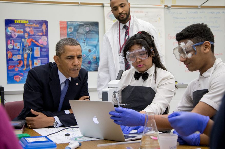 President Obama looks over students' work as he visits a classroom at Bladensburg High School on Monday. At Bladensburg, the Obama administration unveiled the $107 million Youth CareerConnect program designed to "deliver real-world learning opportunities for students" and offer specific training in a given field before a student graduates high school. (Associated Press)