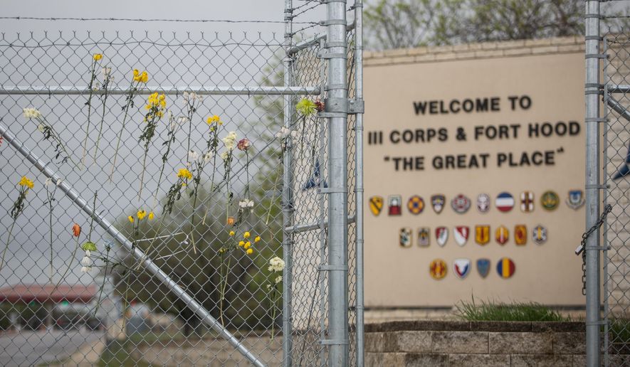 In this file photo, flowers decorate a fence outside of Fort Hood&#x27;s east gate on Sunday, April 6, 2014, in Killeen, Texas, in honor of those killed and wounded in the Fort Hood shooting on April 2.  (AP Photo/ Tamir Kalifa) **FILE**