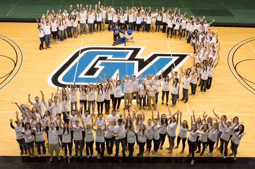 In this Sunday, April 6, 2014 photo released by Grand Valley State University, sets of twins pose for a group photo in the field house at Grand Valley State University in Allendale, Mich. The school says there are 101 sets of twins this year, and that 52 sets of currently enrolled twin students showed up. They were joined by 12 sets of twins who are alumni and even a few infant twins. (AP Photo/Grand Valley State University, Amanda Pitts)