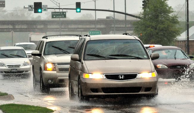 Traffic makes its way through heavy rain throughout the Jackson, Miss.,  area Sunday, April 6, 2014.  On Sunday, street flooding plagued Jackson. Flood advisories for much of the state continued into Monday. (AP Photo/The Clarion-Ledger, Rick Guy )  NO SALES