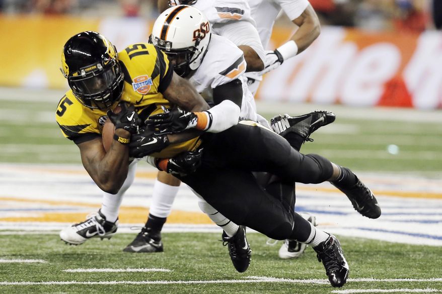 FILE - In this Jan. 3, 2014, file photo, Missouri wide receiver Dorial Green-Beckham (15) is tackled by Oklahoma State safety Daytawion Lowe during the second half of the Cotton Bowl NCAA college football game in Arlington, Texas. Green-Beckham has been suspended indefinitely for an unspecified violation of team rules, three months after he and two friends were arrested on suspicion of felony drug distribution. Coach Gary Pinkel announced the suspension Monday, April 7, in a brief news release. (AP Photo/Brandon Wade, File)
