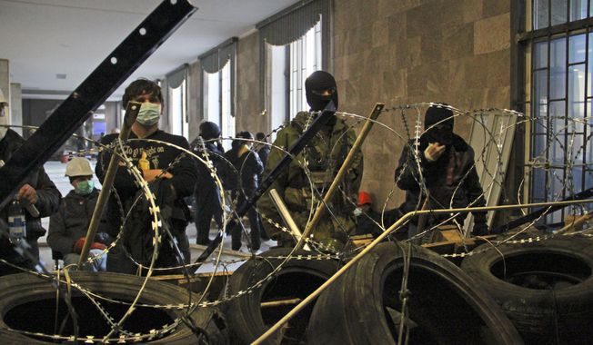 Activists prepare a barricade inside the regional administration building in Donetsk, Ukraine, Monday, April 7, 2014. A Ukrainian news agency is reporting that pro-Russian separatists who have seized the regional administration building in the eastern Ukrainian city of Donetsk proclaimed the region an independent republic. (AP Photo/Alexander Ermochenko)