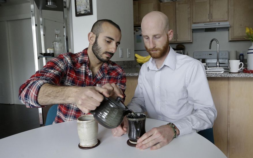 In this April 3, 2014, photo, Derek Kitchen, right, and Moudi Sbeity drink tea at their home, in Salt Lake City. The young couple that has become the face of gay marriage in Utah is an unlikely pair for the role. Kitchen and Sbeity were both raised in conservative religious families that shun gays, Kitchen in a Mormon home in Utah and Sbeity in a Muslim family in Lebanon. They each came out when they were 16 years old, worlds apart, and met six years later in college in Utah. They chose to become one of three couples as plaintiffs in the lawsuit challenging Utah’s same-sex marriage to publicly push back against religions that oppress gays and lesbians. (AP Photo/Rick Bowmer)