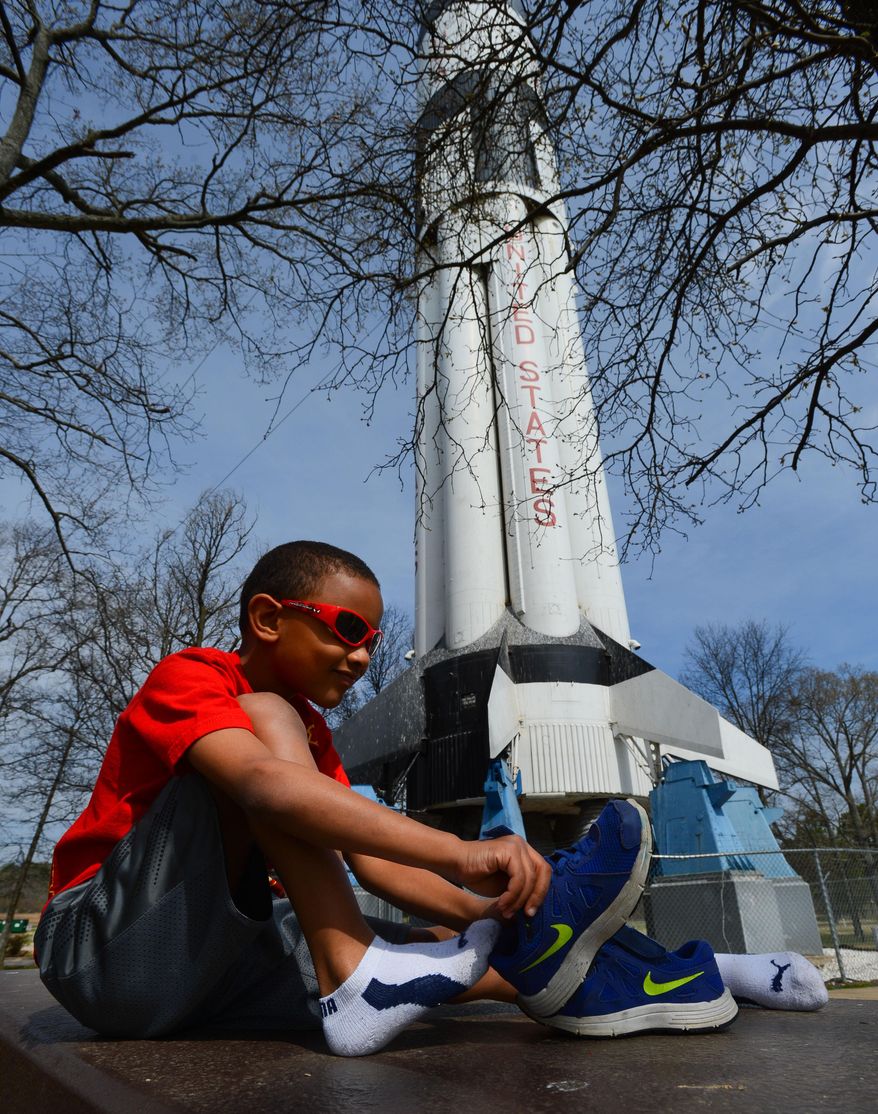 Duane Lyons puts his shoes on while sitting on a picnic table beneath the Saturn 1B Rocket at the Alabama Welcome Center on Interstate 65 on April 2, 2014 in Ardmore, Ala. The paint is faded, and black mold and algae cover the bottom. Birds use the rocket's crevices for nests, and their droppings are everywhere. The U.S. Space and Rocket Center in Huntsville is working with the Alabama Department of Transportation to get it pressure-washed and painted this summer. The state Tourism Department will fund the project. (AP Photo/The Decatur Daily, Gary Cosby Jr.)