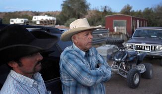 Cliven Bundy, right, and Clance Cox, left, stand at the Bundy ranch near Bunkerville Nev. Saturday, April 5, 2014. The U.S. Bureau of Land Management started taking cattle on Saturday from rancher Bundy, who it says has been trespassing on U.S. land without required grazing permits for over 25 years. Bundy doesn&#39;t recognize federal authority on land he insists belongs to Nevada. (AP Photo/Las Vegas Review-Journal, John Locher)