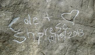 File-In an Oct.. 31, 2013, file photo graffiti spelling &amp;quot;Cole &amp;amp; Shpresa 10/10/2013&amp;quot; is seen carved into the Pompeys Pillar National Monument in Montana. A Minnesota man who carved the names of himself and his wife near the 1806 signature of explorer William Clark on a national monument in south-central Montana last fall has agreed to pay $4,400 in restitution and fines.  (AP PHOTO/THE BILLINGS GAZETTE, Larry Mayer,File )