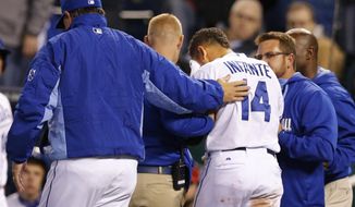 Kansas City Royals manager Ned Yost, left, comforts Omar Infante (14) as trainers help him from the field during the seventh inning of the MLB American League baseball game against the Tampa Bay Rays at Kauffman Stadium in Kansas City, Mo., Monday, April 7, 2014. Infante was hit by a pitch from Tampa Bay Rays relief pitcher Heath Bell. The Royals defeated the Rays 4-2. (AP Photo/Orlin Wagner)