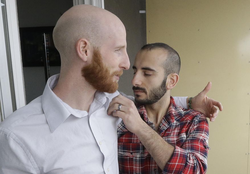 In this April 3, 2014, photo, Derek Kitchen, left, and Moudi Sbeity pose together at their home, in Salt Lake City. The young couple that has become the face of gay marriage in Utah is an unlikely pair for the role. Kitchen and Sbeity were both raised in conservative religious families that shun gays, Kitchen in a Mormon home in Utah and Sbeity in a Muslim family in Lebanon. They each came out when they were 16 years old, worlds apart, and met six years later in college in Utah. They chose to become one of three couples as plaintiffs in the lawsuit challenging Utah’s same-sex marriage to publicly push back against religions that oppress gays and lesbians. (AP Photo/Rick Bowmer)