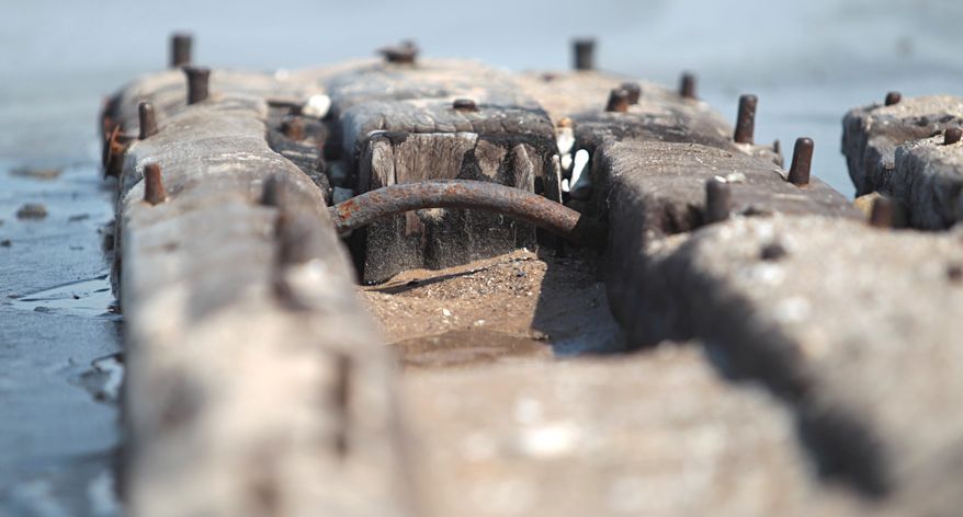 In this photo taken on April 6, 2014, metal pegs stick up from a 40-foot-long section of shipwreck unearthed by winter storms along the Lake Michigan shoreline north of Glen Arbor, Mich., near the Crystal River. The harsh winter and Lake Michigan waves have revealed the wreck of the large boat along a northwestern Lower Peninsula beach that may be more than 100 years old. (AP Photo/Traverse City Record-Eagle, Nathan Payne) MANDATORY CREDIT