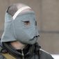 Pro-Russian activist wears a hand-made mask behind a barricade in front of the regional administration building in Donetsk, Ukraine, Tuesday, April 8, 2014, as the makings of an improved self-appointed government began to take shape, with demonstrators dug in for their third day at the 11-storey regional headquarters. Ukrainian authorities on Tuesday reasserted control over an administration building in the country’s second-largest city of Kharkiv, 250 Km ( 155 miles) north of Donetsk, which had been seized by pro-Russian protesters, and authorities detained some dozens. (AP Photo/Efrem Lukatsky)