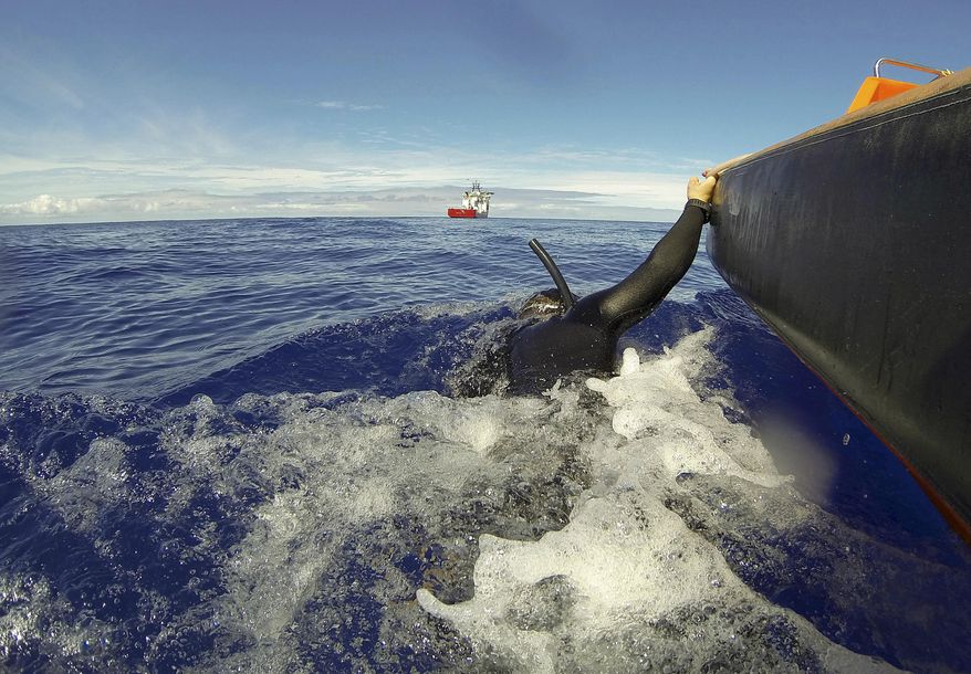 In this April 7, 2014 photo provided by the Australian Defense Force Able Seaman Clearance Diver Michael Arnold is towed by a fast response craft from the Australian Defense's ship Ocean Shield as he scans the water for debris of the missing Malaysia Airlines Flight 370 in the southern Indian Ocean. Up to 14 planes and as many ships were focusing on a single search area covering 77, 580 square kilometers (29,954 square miles) of ocean, 2,270 kilometers (1,400 miles) northwest of the Australian west coast city of Perth, Australia. (AP Photo/Australian Defense Force, Lt. Ryan Davis) EDITORIAL USE ONLY