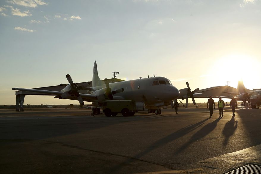 Flight crew from a Royal Australian Air Force P-3 Orion walk towards the aircraft at RAAF Base Pearce as it arrives back from the on-going search operations for missing Malaysia Airlines Flight 370 in Perth, Australia, Tuesday, April 8, 2014. Search crews have failed to relocate faint sounds heard deep in the Indian Ocean, possibly from the missing jetliner's black boxes whose batteries are at the end of their life. (AP Photo/Rob Griffith)