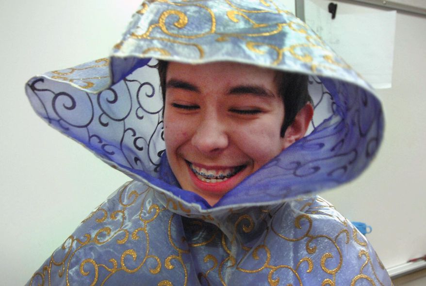 In this March 20, 2014 photo, Noe Cornejo, who plays Calpernia, laughs as he dresses up in his Roman costume as students prepare to perform Shakespeare's "Julius Caesar," at Normal Community High School in Normal, Ill. (AP Photo/The Pantagraph, David Proeber)