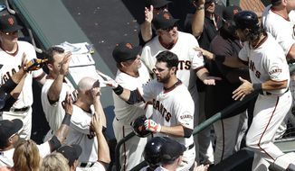 San Francisco Giants&#x27; Brandon Belt, center, is congratulated after hitting a two-run home run off of Arizona Diamondbacks pitcher Trevor Cahill that scored Angel Pagan, right, during the first inning of the home opener MLB National League baseball game in San Francisco, Tuesday, April 8, 2014. (AP Photo/Jeff Chiu)