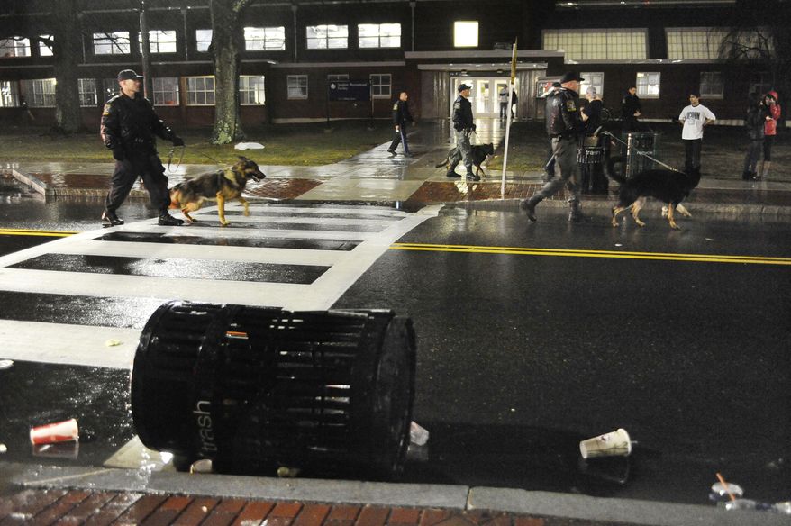 Connecticut State Police use dogs to move clear students from an area they had gathered to celebrate their team's 60-54 victory over Kentucky in the NCAA Final Four tournament college basketball championship game, Monday, April 7, 2014, in Storrs, Conn. (AP Photo/Jessica Hill)