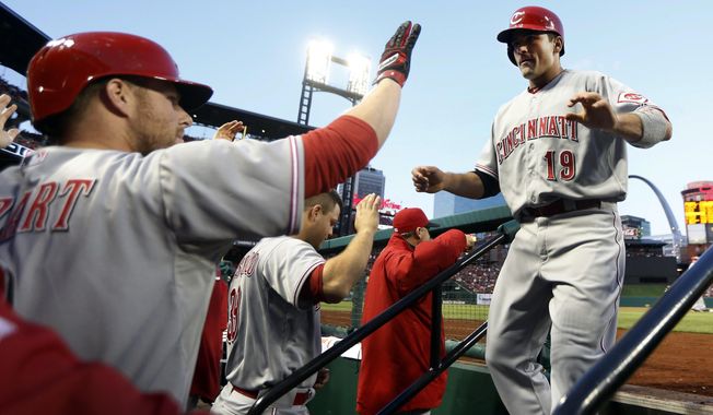 Cincinnati Reds&#x27; Joey Votto, right, is congratulated by teammate Zack Cozart, left, after scoring on a two-run triple by Jay Bruce during the first inning of a baseball game against the St. Louis Cardinals on Tuesday, April 8, 2014, in St. Louis. (AP Photo/Jeff Roberson)