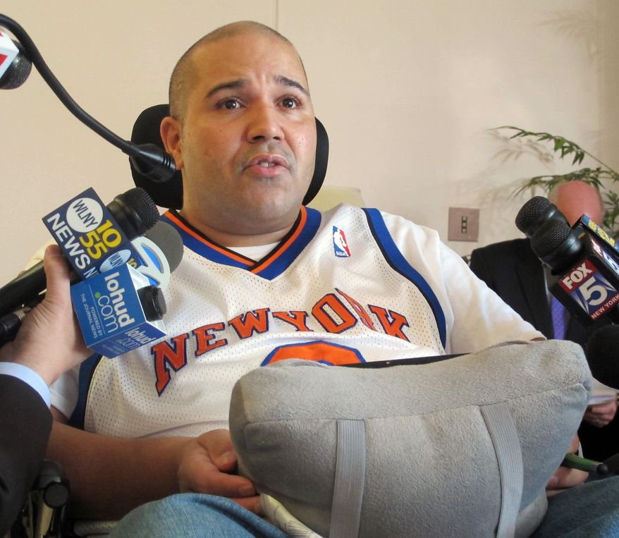 Samuel Rivera of Ossining, N.Y., speaks with reporters Wednesday, April 9, 2014, in White Plains, N.Y., about the injuries he received in a Dec. 1, 2013, Metro-North Railroad derailment. Rivera, a Metro-North Railroad mechanic, says he was paralyzed in the deadly commuter train derailment in New York City and is suing for $100 million. The lawsuit says Rivera, a passenger on the train that derailed, suffered injuries including spinal cord damage that resulted in quadriplegia. (AP Photo/Jim Fitzgerald)