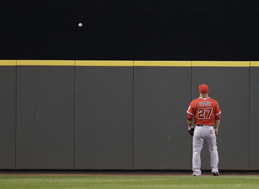 Los Angeles Angels center fielder Mike Trout can only watch as a solo home run hit by Seattle Mariners' Corey Hart goes over the wall in the seventh inning of a baseball game, Tuesday, April 8, 2014, in Seattle. It was Hart's second home run of the game. (AP Photo/Ted S. Warren)