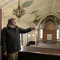 In this March 19, 2014 photo, Plainfield, Ill. village planner Michael Garrigan gives a tour of the dilapidated St. Mary’s Catholic Church  in Plainfield,. The building was acquired by the village and minimally restored. It has attracted interest from potential business developers. (AP Photo/The Herald-News, Rob Winner)  MANDATORY CREDIT