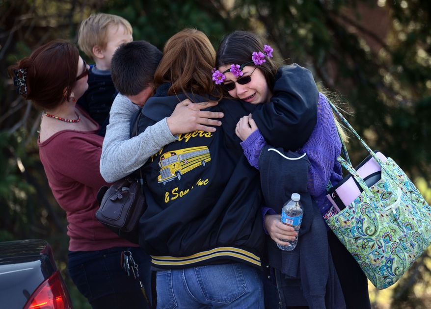 Parents and students embrace along School Road near Franklin Regional High School after more than a dozen students were stabbed by a knife wielding suspect at the school on Wednesday, April 9, 2014, in Murrysville, Pa., near Pittsburgh. The suspect, a male student, was taken into custody and is being questioned. (AP Photo/Tribune Review, Sean Stipp)