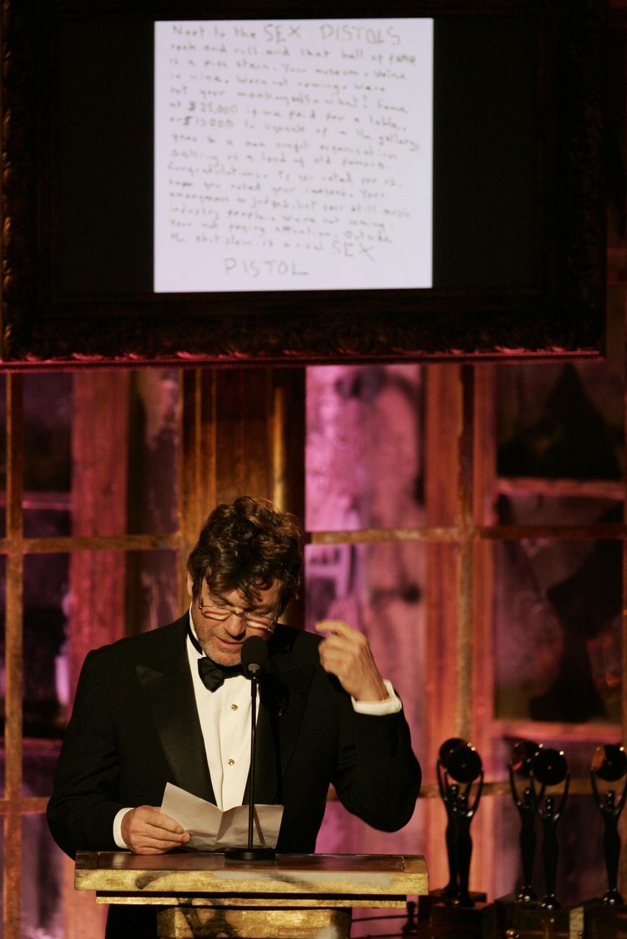 FILE- In this March 13, 2006 file photo, Jann Wenner, vice chairman of the Rock & Roll Hall of Fame board of directors, reads a letter from the Sex Pistols refusing to attend their own induction into the Rock & Roll Hall of Fame during ceremonies, in New York. The British band, which featured lead singer Johnny Rotten and late bassist Sid Vicious, said in a hand-written note posted on its website that the hall was like "urine in wine" selling "old famous": "Were not coming. Were not your monkeys and so what?" (AP Photo/Jeff Christensen, file)