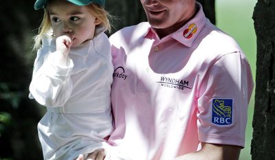 Brandt Snedeker carries his daughter Lily during the par three competition at the Masters golf tournament Wednesday, April 9, 2014, in Augusta, Ga. (AP Photo/David J. Phillip)