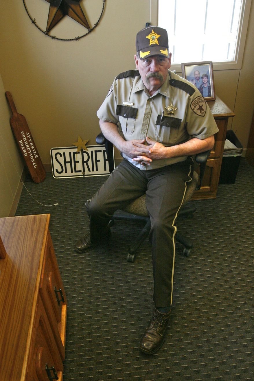 ADVANCE FOR USE SUNDAY, APRIL 13, 2014 AND THEREAFTER - Williams County, N.D. Sheriff Scott Busching sits at his desk in Williston, N.D. on Tuesday, Feb. 25, 2014. Years ago, homegrown meth was a scourge in North Dakota but its supply was sharply reduced by a crackdown on "mom-and-pop" meth labs and legislation that made it harder to buy ingredients. These days, the drug trade looks a lot different. Meth is still most common, but most of it originates in Mexico and is more potent. Heroin is more visible, something that "scares me," says Busching, who says he'd probably rate the drug problem in his county a 7 on a scale of 10. (AP Photo/Martha Irvine)