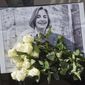 FILE - In this Saturday, April 5, 2014 file photo, roses lay in front of a picture of the Associated Press photographer Anja Niedringhaus, 48, who was killed April 4, 2014 in Afghanistan, in Paris.  Fellow officers say the Afghan police commander who killed Niedringhaus and wounded reporter Kathy Gannon seemed a calm, pious man who may have come under the influence of Islamic fundamentalists calling for vengeance against foreigners over drone strikes. (AP Photo/Michel Euler, File)
