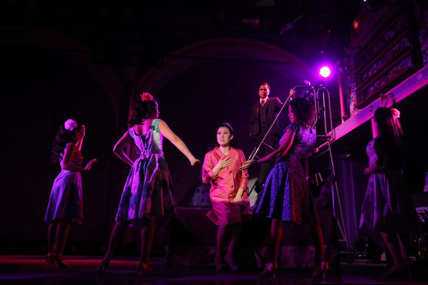 This undated theater image released by The Public Theater shows Ruthie Ann Miles, center, during a performance of "Here Lies Love," in New York. When it was in the Public's LuEsther Hall last year, the show had a capacity of 160. This time, Dave Byrne and a group of commercial producers are hoping to push that number to 200. Byrne, who teamed up with Fatboy Slim on the music, has been shepherding the show for 10 years. (AP Photo/The Public Theater, Joan Marcus)