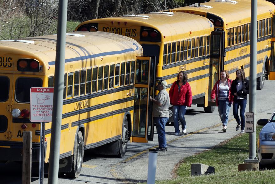 Students walk past a row of buses as they leave the campus of the Franklin Regional School District after more then a dozen students were stabbed by a knife wielding suspect at nearby Franklin Regional High School on Wednesday, April 9, 2014, in Murrysville, Pa., near Pittsburgh. The suspect, a male student, was taken into custody and is being questioned. (AP Photo/Gene J. Puskar)