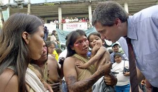 Lawyer Steven Donziger, right, speaks to  Huaorani women during this first day of the trial against Chevron-Texaco, in Lago Agrio, Tuesday, Oct. 21, 2003. A decade after Texaco pulled out of the Amazon jungle, the U.S. petroleum giant went on trial Tuesday in a lawsuit filed on behalf of 30,000 poor Ecuadoreans who say the company&#x27;s 20 years of drilling poisoned their homeland.  (AP Photo/Dolores Ochoa)