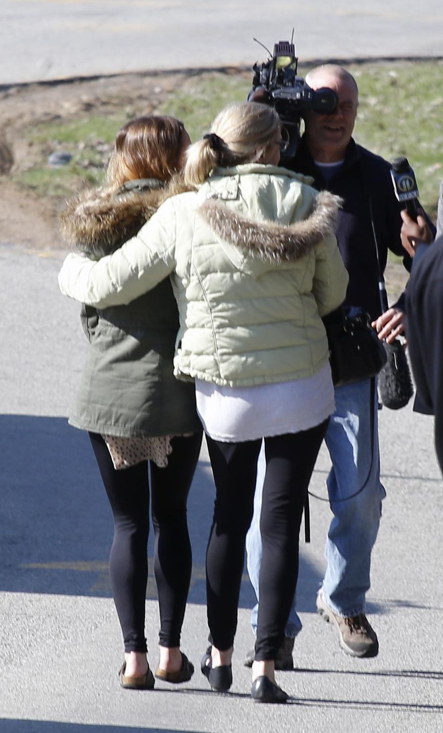 A pair of women walk arm-in-arm off the campus of the Franklin Regional School District, where several people were stabbed at Franklin Regional High School on Wednesday, April 9, 2014, in Murrysville, Pa., near Pittsburgh. The suspect, a male student, was taken into custody and being questioned. (AP Photo/Keith Srakocic)