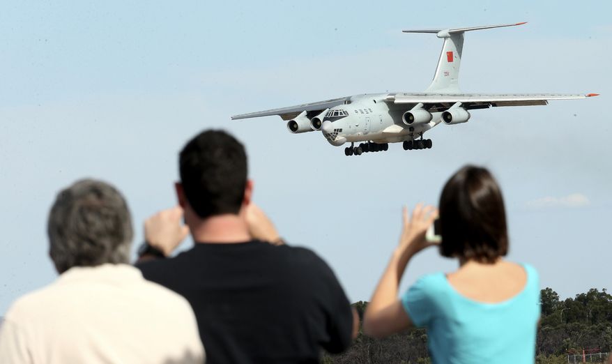 Spectators take photos of a Chinese Ilyushin IL-76 aircraft as it comes in for a landing at Perth International Airport after returning from the ongoing search operations for missing Malaysia Airlines Flight 370 in Perth, Australia, Thursday, April 10, 2014. With hopes high that search crews are zeroing in on the missing Malaysian jetliner's crash site, ships and planes hunting for the aircraft intensified their efforts Thursday after equipment picked up sounds consistent with a plane's black box in the deep waters of the Indian Ocean. (AP Photo/Rob Griffith)