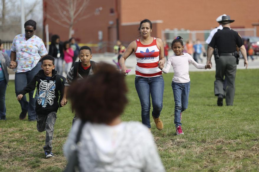 Students and parents are reunited after a lockdown in response to a shooting in the parking lot of Liberty Elementary. The lock down happened just minutes before the students there were to be dismissed, Thursday, April 10, 2014 in Columbus, Ohio. (AP Photo/Columbus Dispatch, Courtney Hergesheimer)