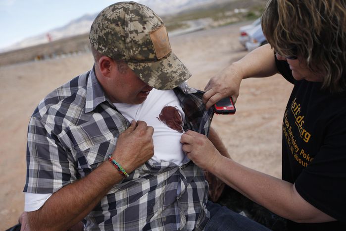 Krissy Thornton, right, looks at blood from a taser wound on Ammon Bundy near Bunkerville, Nev. Wednesday, April 9, 2014. Bundy was tasered by Bureau of Land Management law enforcement officers while protesting the roundup of what the BLM calls &amp;quot;trespass cattle&amp;quot; that rancher Cliven Bundy grazes in the Gold Butte area 80 miles northeast of Las Vegas. (AP Photo/Las Vegas Review-Journal, John Locher)