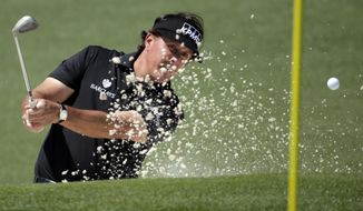 Phil Mickelson hits out of a bunker on the second hole during the first round of the Masters golf tournament Thursday, April 10, 2014, in Augusta, Ga. (AP Photo/Chris Carlson)