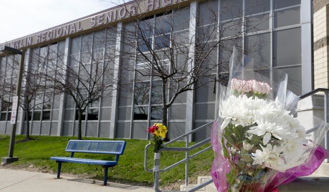 A bouquet of flowers is taped to a stairway rail near the closed entrance to Franklin Regional High School near Pittsburgh, on Thursday, April 10, 2014 in Murrysville, Pa. A knife wielding student injured over 20 people in a stabbing attack there on April 9. (AP Photo/Keith Srakocic)