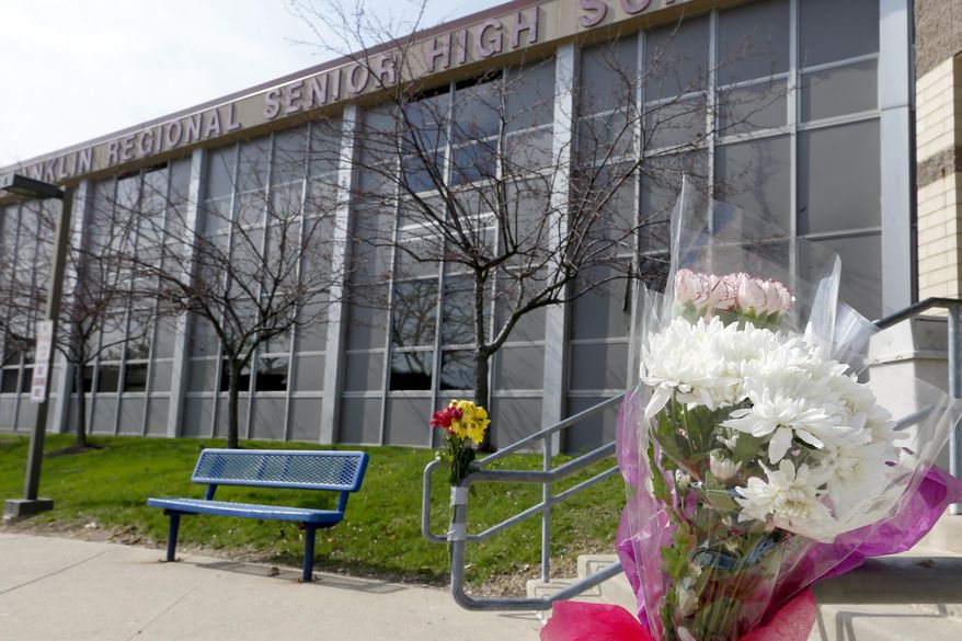 A bouquet of flowers is taped to a stairway rail near the closed entrance to Franklin Regional High School near Pittsburgh, on Thursday, April 10, 2014 in Murrysville, Pa. A knife wielding student injured over 20 people in a stabbing attack there on April 9. (AP Photo/Keith Srakocic)