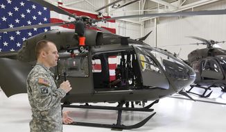 Mike Mauss a helicopter instructor pilot describes the differences between the two new UH-72A Lakota helicopters to the media at the Iowa Army National Guard Air Aviation Support Facility Thursday, April 10, 2014, in Waterloo, Iowa.  (AP Photo/Waterloo Courier, Matthew Putney)