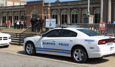 A police car is parked outside East High School during a lockdown of the school Friday, April 11, 2014, in Memphis, Tenn. Police searched the school after a report of four armed people inside the building, but no intruders were found, authorities said. (AP Photo/Adrian Sainz)