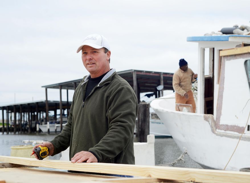 CORRECTS SPELLING - Bert Ducote measures a piece of lumber for his boat, which is being rebuilt at the Lake Catherine Marina in New Orleans, Friday, March 7, 2014. Ducote has had dozens of boils pop up on his skin since performing cleanup work during the Deepwater Horizon oil spill. (AP Photo/Andrea Mabry)