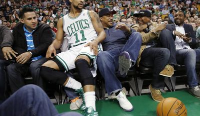 Fans react after Boston Celtics' Jerryd Bayless (11) went into the seats in the second quarter of an NBA basketball game against the Charlotte Bobcats in Boston, Friday, April 11, 2014. (AP Photo/Michael Dwyer)