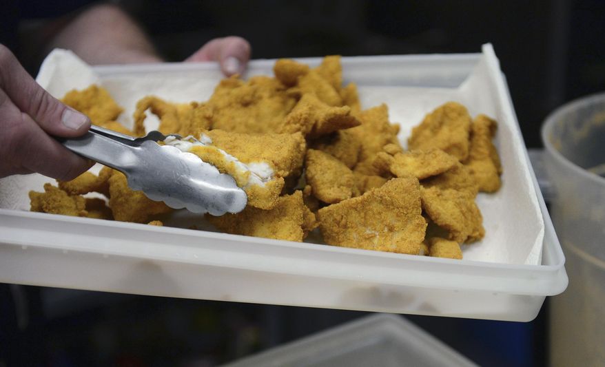 In this March 25, 2014 photo, breaded and fried Asian carp are seen at Dixon Seafoods in East Peoria, Ill., where chef Clint Carter gave cooking classes on how to prepare the fish for local chefs who will be serving their own culinary creations at the Flying Fish Festival in July at East Peoria. (AP Photo/Journal Star, Fred Zwicky)