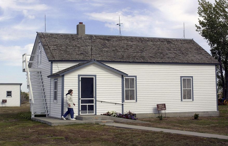FILE - In this Oct. 10, 2002 file photo, Edna Schwab walks toward the front door of Lawrence Welk's boyhood home in Strasburg, N.D. The North Dakota State Historical Society is meeting Friday, April 11, 2014, in Bismarck, N.D. to get an update on its purchase of the famous band leader's home. The group voted 6-5 in January to buy the Strasburg homestead from Welk's nieces, but a final sale price was not negotiated. (AP Photo/Will Kincaid, File)