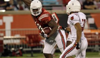 Louisville&#x27;s Gerald Christian, left, makes a catch off balance in front of defender Jordan Streeter, right, in their NCAA college spring football game in Louisville, Ky., Friday, April 11, 2014.  (AP Photo/Garry Jones)