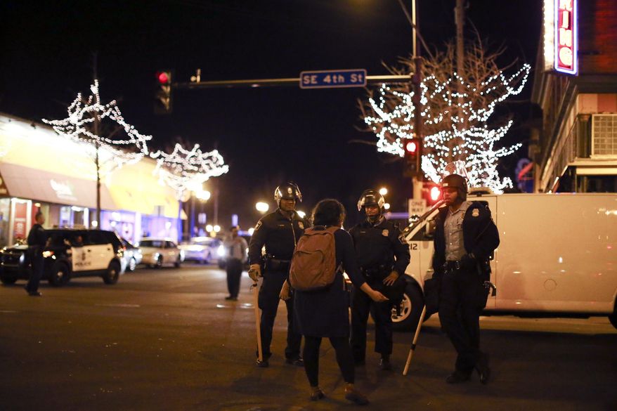 Police in riot gear stood guard following a celebration by University of Minnesota hockey fans after the Gophers last-second NCAA college hockey Frozen Four semifinal win, Friday, April 11, 2014, in Minneapolis, Minn. Hundreds of students and other hockey fans took to the streets in Dinkytown near campus to celebrate the victory over North Dakota Thursday night. (AP Photo/The Star Tribune, Jeff Wheeler)