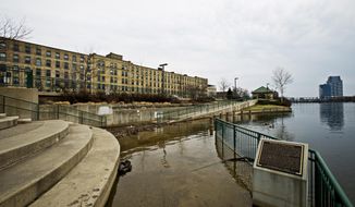 In this photo taken on Thursday, April 10, 2014, the Grand River flows over its bank submerging a section of Canal Park in Grand Rapids, Mich. According to the National Weather Service, the Grand Rapids area is expecting rain throughout the weekend. (AP Photo/The Grand Rapids Press, Andrew Kuhn) ALL LOCAL TV OUT; LOCAL TV INTERNET OUT