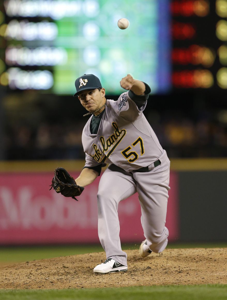 Oakland Athletics starting pitcher Tommy Milone throws against the Seattle Mariners in the third inning of a baseball game, Friday, April 11, 2014, in Seattle. (AP Photo/Ted S. Warren)